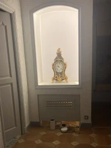 Niche murale rétroéclairée réalisée par EDVA Rénovation pour mettre en valeur une horloge ancienne et apporter du caractère à l’intérieur