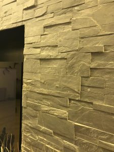 Détail d’un mur en pierre avec intégration d’un écran dans une niche – EDVA